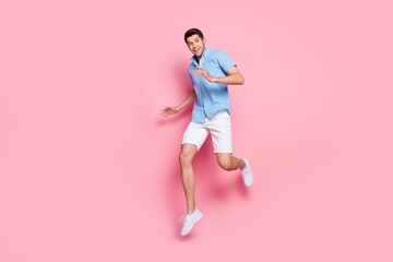 Fototapeta na wymiar Photo of nice attractive man jump enjoy vacation wear blue shirt shorts sneakers isolated on pink color background
