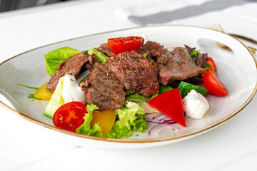Fillet of beef with vegetable salad on wooden table