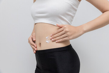 Woman applying moisturizer cream lotion to her abdomen. Belly fat removal and weight loss. girl wearing underwear