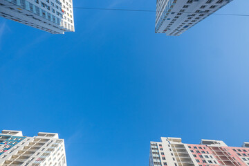 four high-rise buildings at the corners of the frame and a blue sky