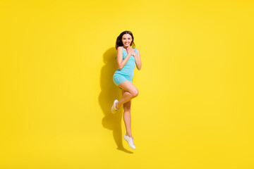 Fototapeta na wymiar Full size photo of impressed brunette hairdo young lady jump wear teal dress isolated on vivid yellow color background