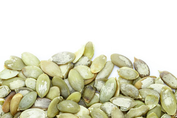 Close-up background texture of green pumpkin seeds on a white background. Space for text.