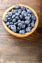 Fresh blueberries in a wooden bowl. Healthy and dietary food concept.