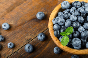 Obraz na płótnie Canvas Freshly picked blueberries in a wooden bowl. Healthy berry, organic food, antioxidant, vitamin