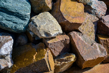 Background is made of natural stones of different colors and sizes. Natural texture. Brown granite.Top view. Close-up.  Selective focus.