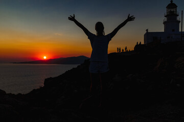 Fototapeta premium Silhouette of a happy young man person during a golden sunset in Mykonos, Greece