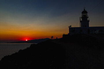Silhouette of a lighthouse during orange sunset in Mykonos, Greece