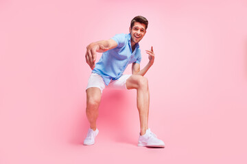 Full length body size photo smiling man in blue shirt dancing at party in summer isolated pastel pink color background