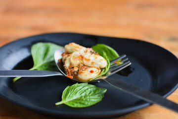 Oyster salad in a black bowl on the dining table