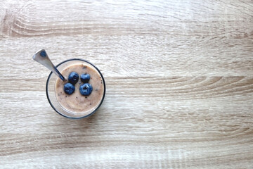 Obraz na płótnie Canvas Banana and blueberry vegan nice cream, served on wooden table. Flat lay.