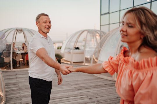 a man and a woman in love walk to a rooftop cafe on a date.