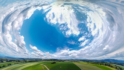 Abstract panoramic aerial view in a forest and field with fantastic beautiful clouds and curvature...