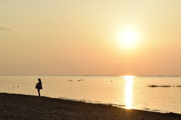 person walking on the beach at sunset