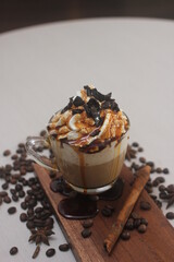 a fresh caramel macchiato served with whipped cream, caramel syrup and crumb of chocolate 