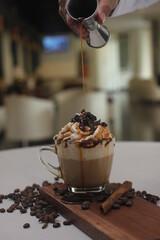 a fresh caramel macchiato served with whipped cream, caramel syrup and crumb of chocolate 