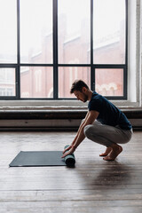 A young man performing yoga asanas and sports exercises to improve the strength and flexibility of the body