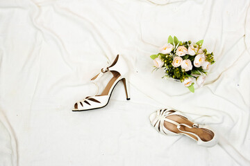Bridal Shoes and bouquet of flowers. Wedding concept on bed 