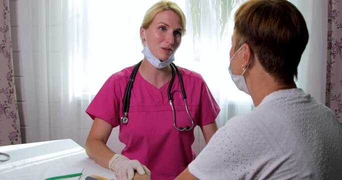 The girl the doctor reassures the woman about a good examination. The girl doctor smiles amiably at the patient. Health and medicine concept.