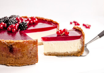 cheesecake topped with raspberry jelly, garnished with blackberries and red currants 