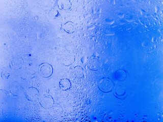 Misted glass, colorful abstract rainbow colored mist rain drops dew drops water droplets condensation on rainbow tinted glass window