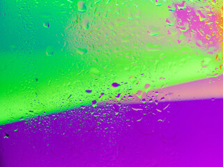 Misted glass, colorful abstract rainbow colored mist rain drops dew drops water droplets condensation on rainbow tinted glass window