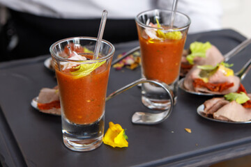 The waiter holds a tray with light snacks in his hands