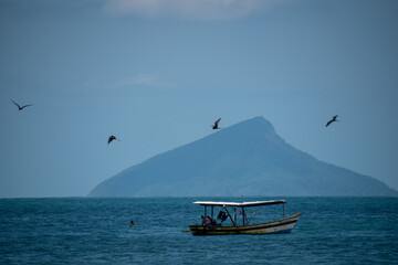 barco de pesca, p&aacute;ssaros e ilhas