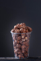 Gourmet sweet popcorn in plastic cup. Chocolate flavor.