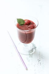 Fresh smoothie in a glass. Bright wooden background. Close up.
