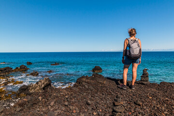 Female Hiker Overlooking Tide Pools and Exposed Lava Reef on Anaeho'omalu Bay, Hawaii Island, Hawaii, USA