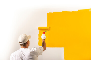 Male decorator painting a wall - obrazy, fototapety, plakaty