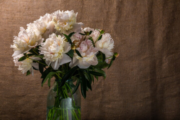 bouquet of white peony flowers in a glass jar side view