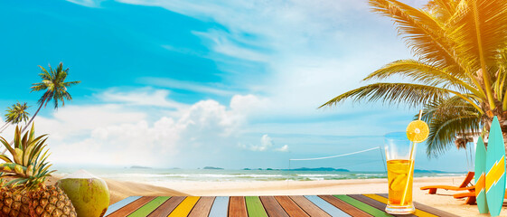 Panoramic tropical sea view with the sunny day. On the table are drinks and tropical fruits. A fun summer vacation getaway with outdoor activities, swimming, surfing, volleyball, and beach parties.