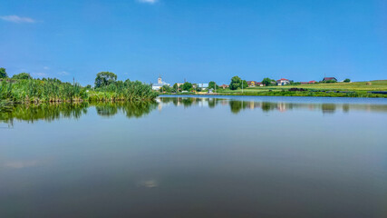 Fototapeta premium Landscape with a lake and clouds in the sky in the summer season