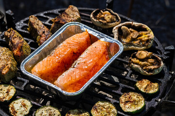 veal meat, salmon and zucchini on garden grill with charcoal