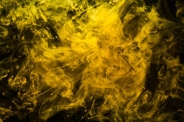 Fototapeta na wymiar Abstract liquid art, yellow smoke bomb on black background, amber color acrylic paints under water