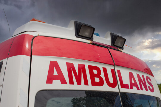 Closeup shot of ambulans text in the rear side of a van under a gloomy sky