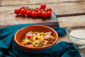 Risotto with mushrooms in a plate on a wooden background on a blue napkin and ingredients.