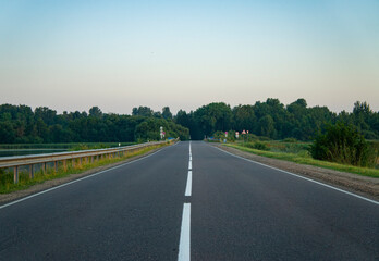 Calm empty asphalt road without cars at sunrise