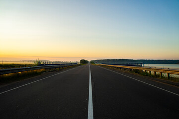 Calm empty asphalt road without cars at sunrise