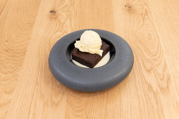 chocolate brownie with vanilla ice cream on wooden table