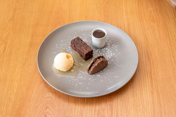 Chocolate brownie dessert, with macaroon biscuit, vanilla ice cream, dark chocolate cream and honey syrup