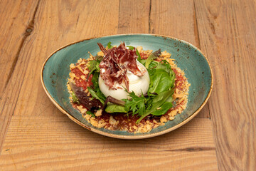 Iberian burrata salad with ball cheese, Iberian ham, crushed tomato and breadcrumbs with sprouts of lettuce mixed with olive oil