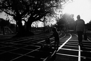 silhouette of child and his mother walking in a park