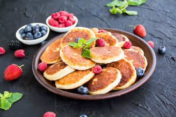 A healthy breakfast of cheese pancakes, berries, and honey. Creative atmospheric decoration