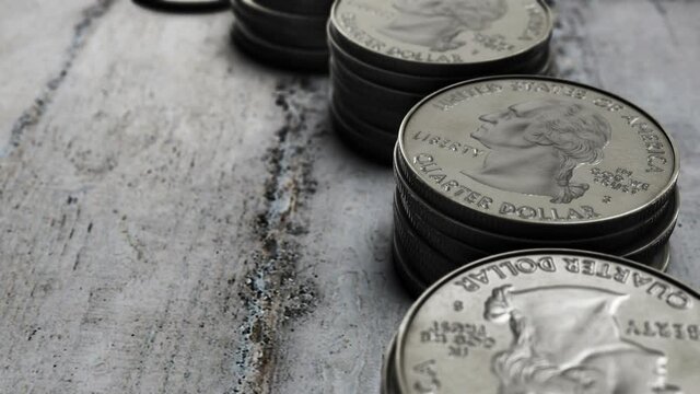 A 4K footage of stacks of Washington quarter coins on a rock surface