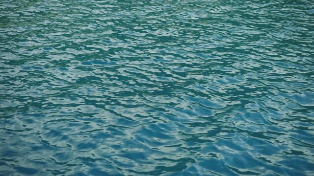Full frame footage of rippled water surface of lake or sea. Nature background. Tranquil outdoor scene.