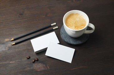 Obraz na płótnie Canvas Blank business cards, pencils and coffee cup on wooden background. Template for ID.