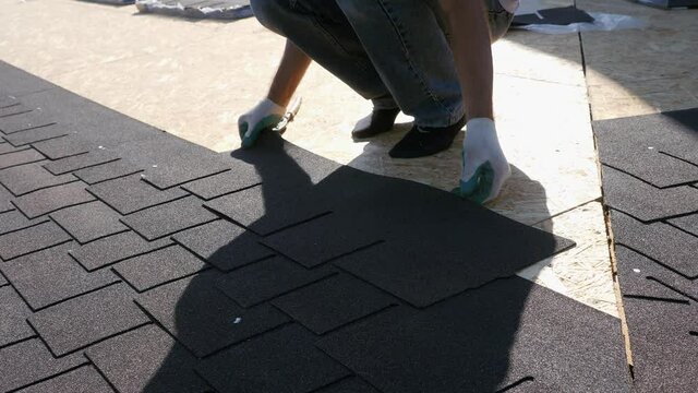 Roofing works. Laying of a soft tile element on the slab. Installation of the roof to the base.