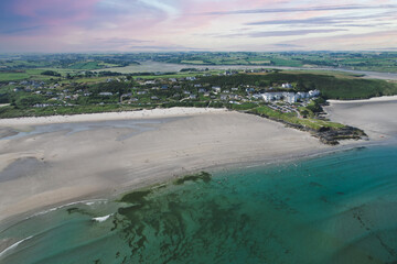 Aerial view of Inchydoney beach near Clonakilty in Ireland with people in the turquoise water on a warm summer day